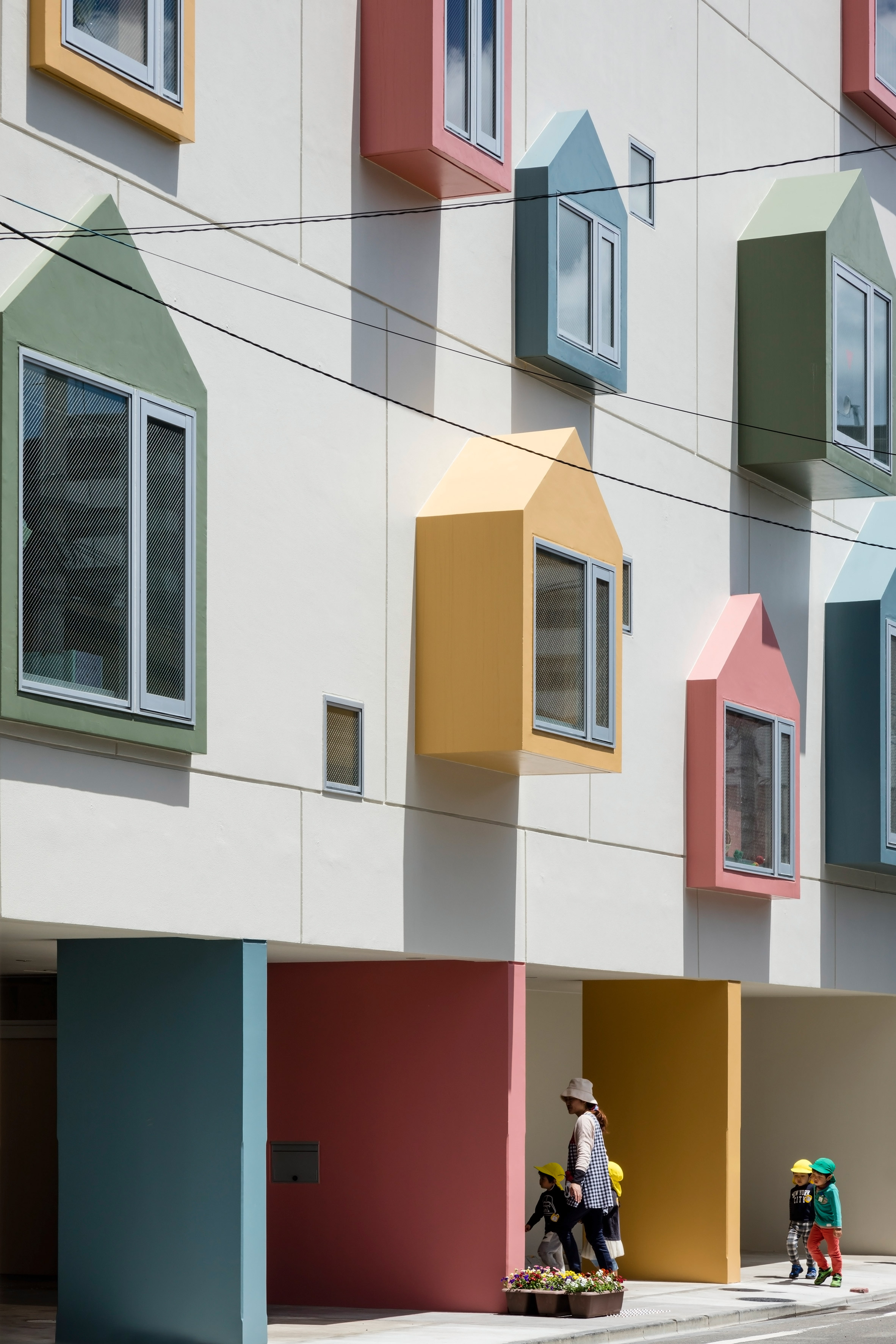 Colourful house-shaped boxes surround windows at nursery school in northern Japan 