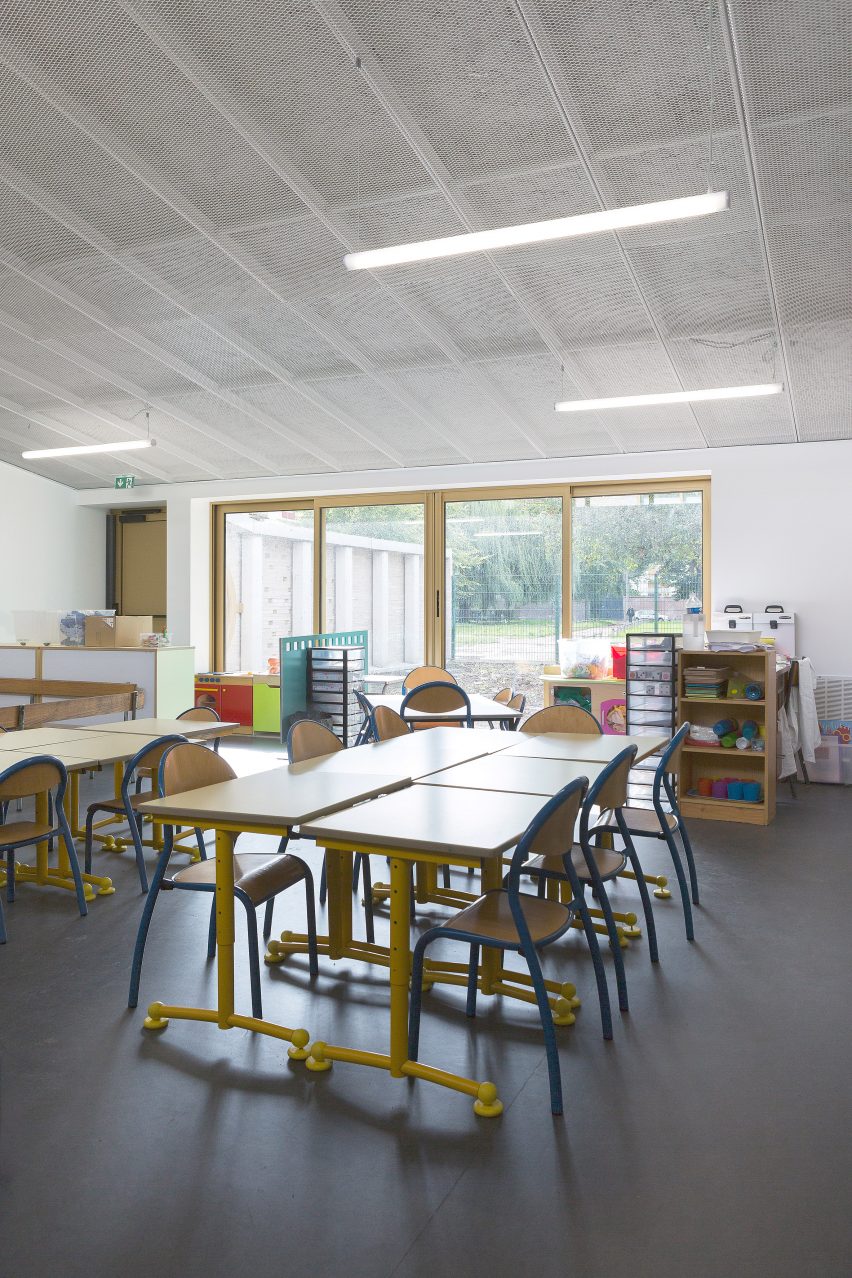 LT2A's brick school extension features porthole-like screens and gold-hued surfaces