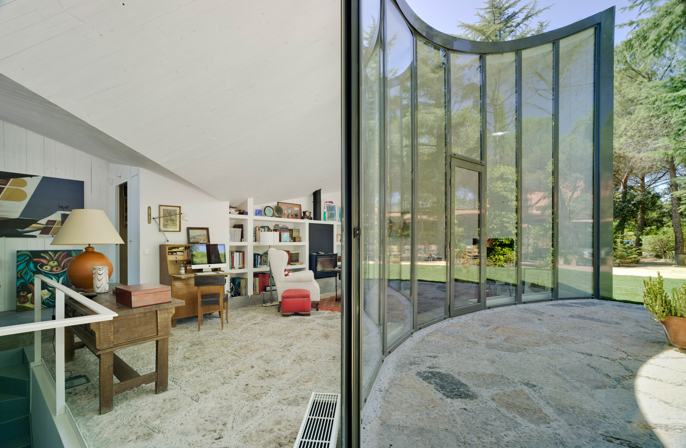 Spanish architect Alejandro Valdivieso has repurposed a former water cistern near Madrid, transforming it into the basement of a house featuring a glass facade that curves around the original well.