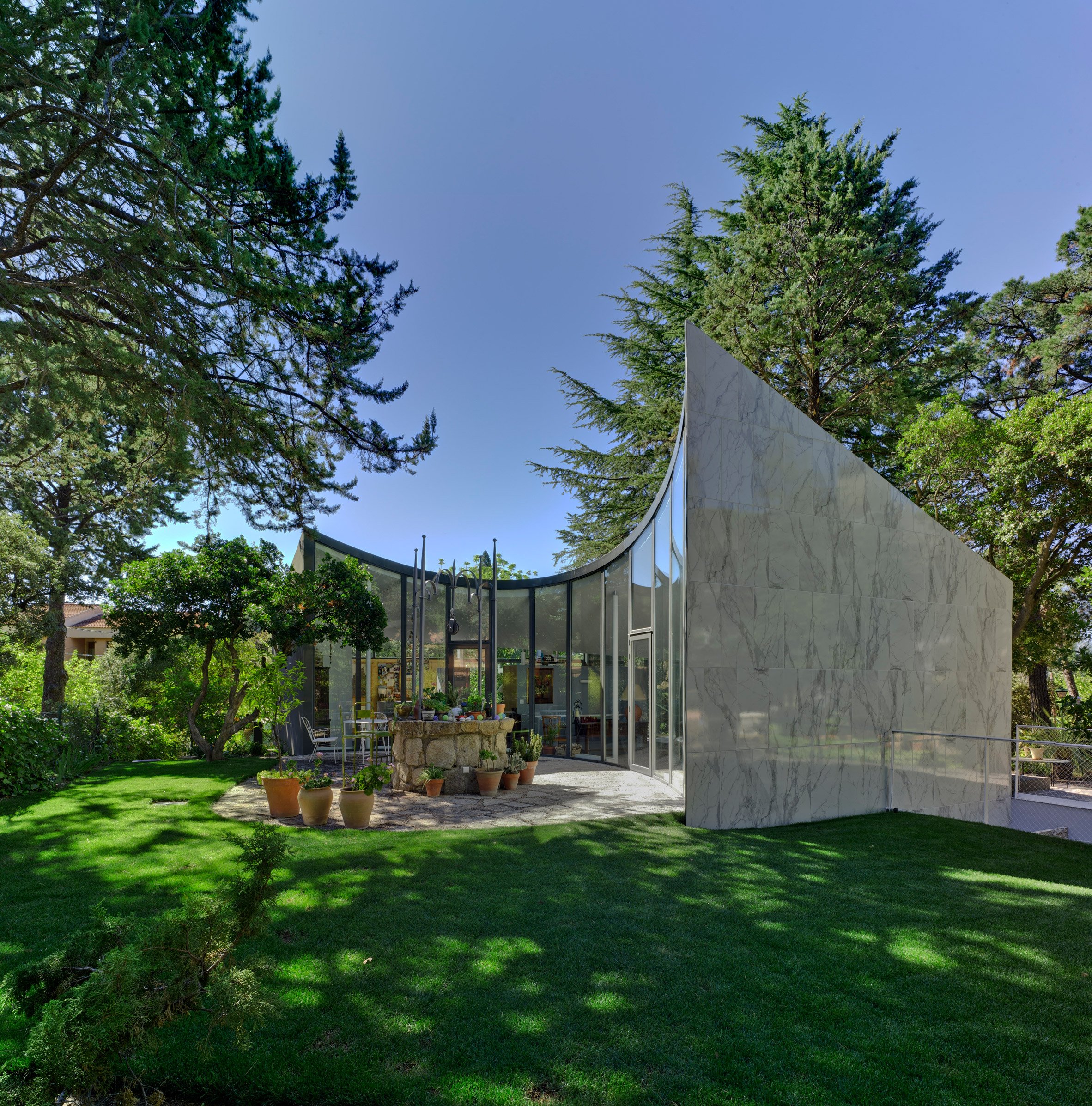 Spanish architect Alejandro Valdivieso has repurposed a former water cistern near Madrid, transforming it into the basement of a house featuring a glass facade that curves around the original well.