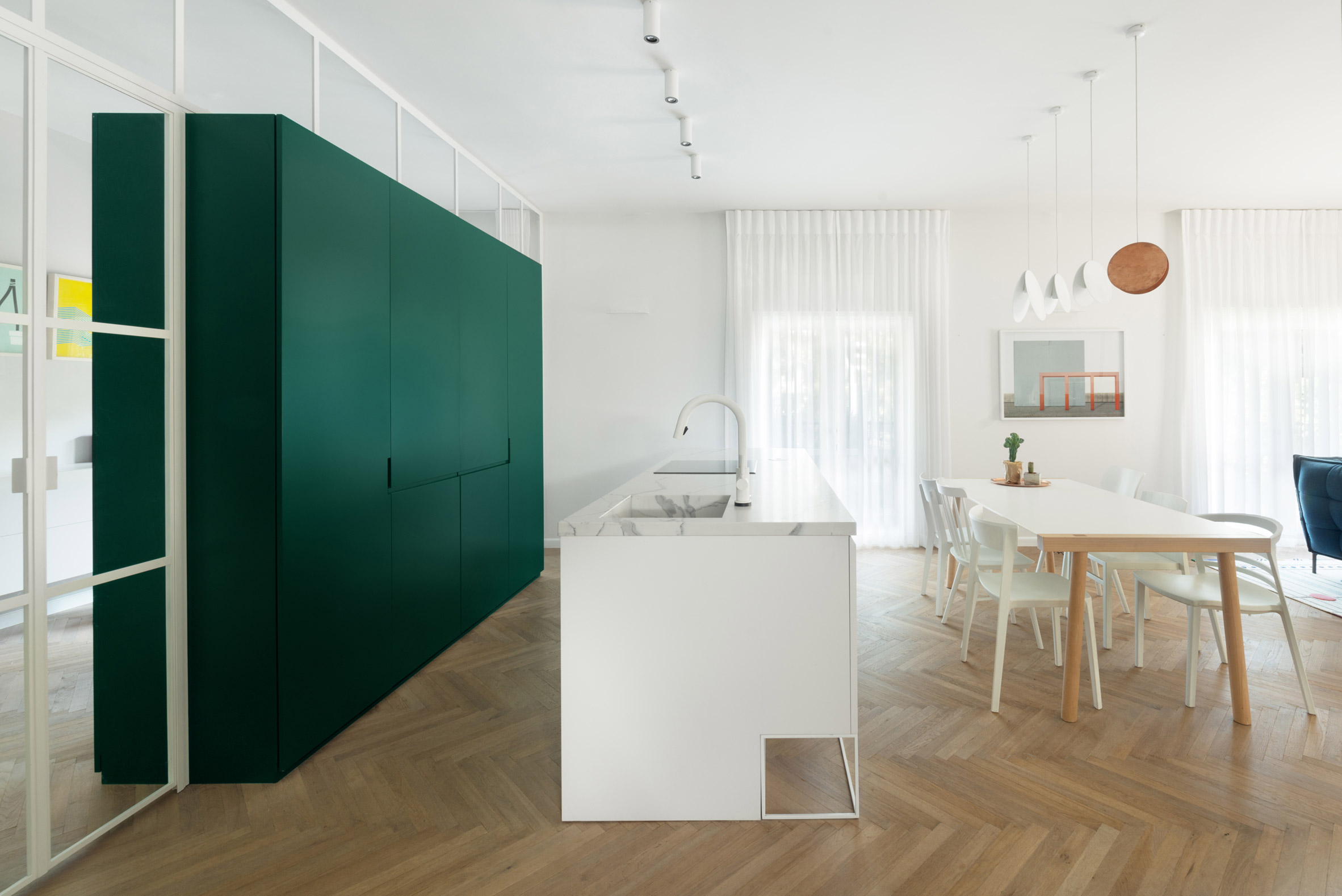 Colourful cabinetry offsets white interior of Bauhaus-era apartment in Tel Aviv