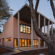 Concrete portico provides sheltered outdoor space for pink brick house in Seville