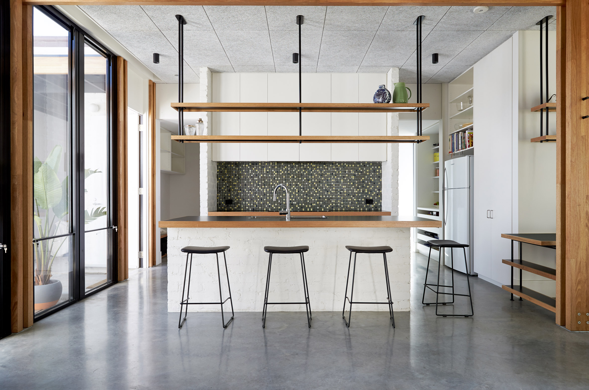 This single-storey house in Melbourne has been renovated by local studio Foomann to include exposed wooden beams that span the entirety of the property.