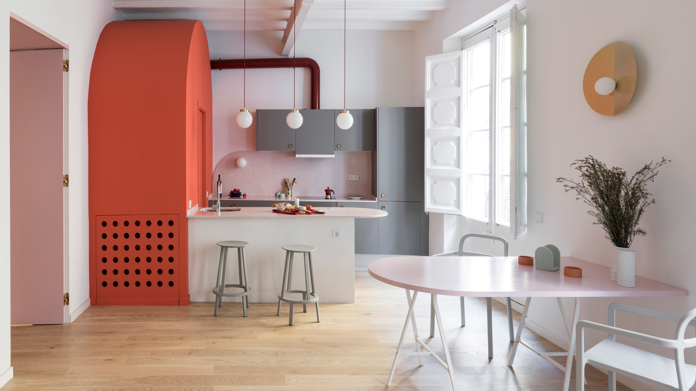 Deep-blue cabinetry and coral-pink arches redefine Barcelona apartment