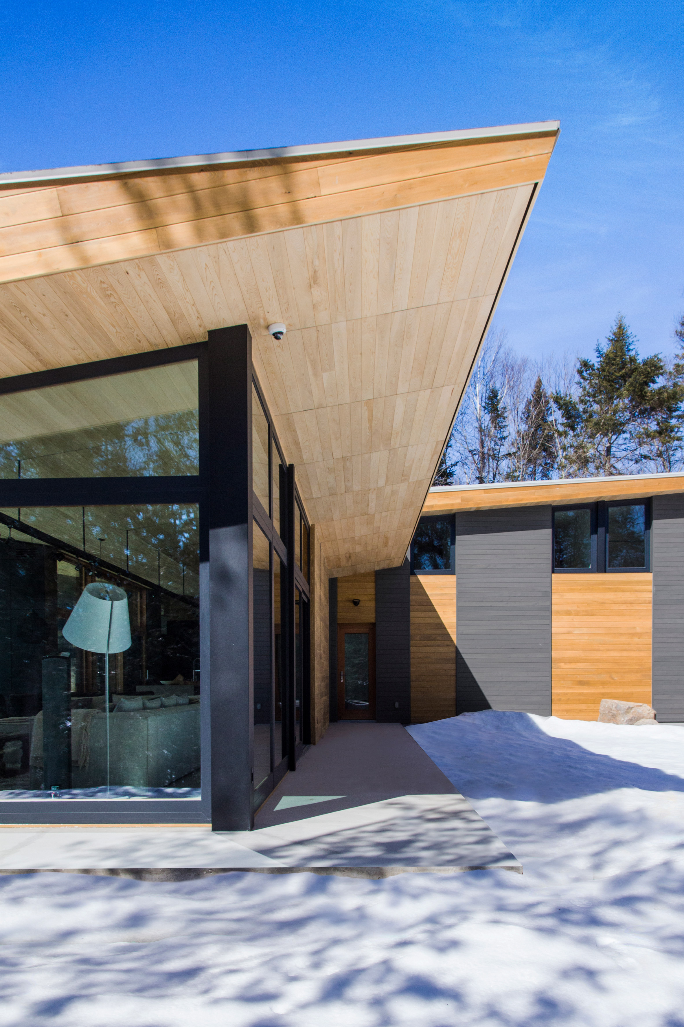 Bird's wings inform V-shaped roof over Quebec ski chalet by YH2