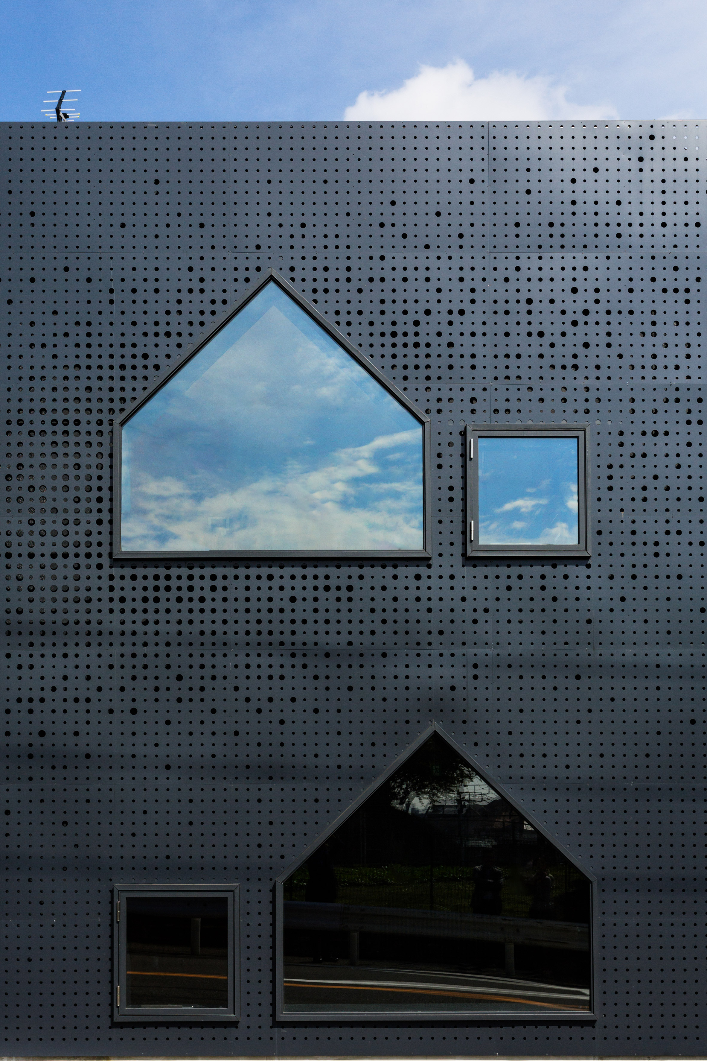 House-shaped windows puncture perforated-metal facades of Yokohama nursery