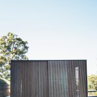 Sliding eucalyptus-wood screens wrap exterior of house on Australia's Sunshine Coast
