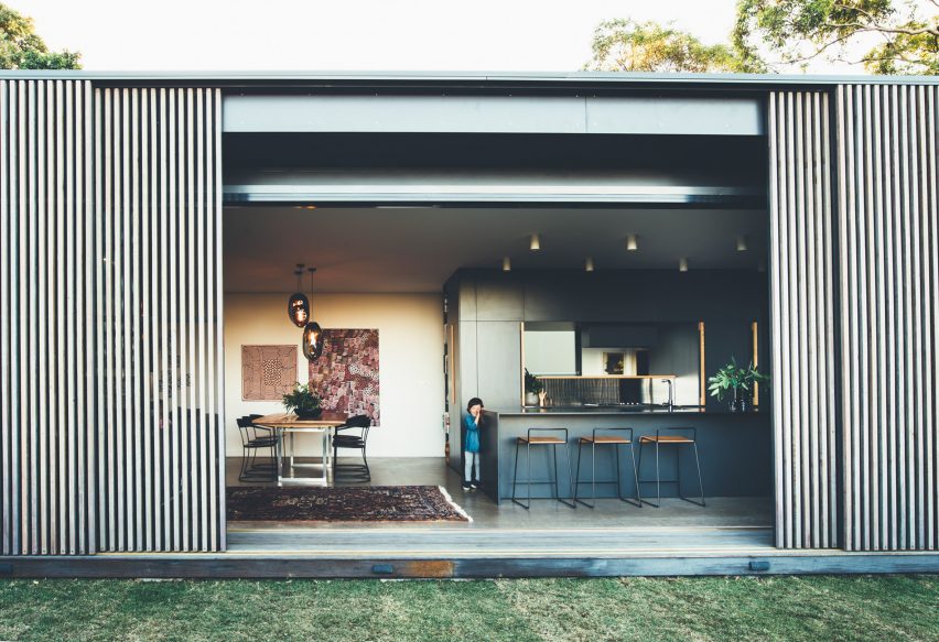 Sliding eucalyptus-wood screens wrap exterior of house on Australia's Sunshine Coast