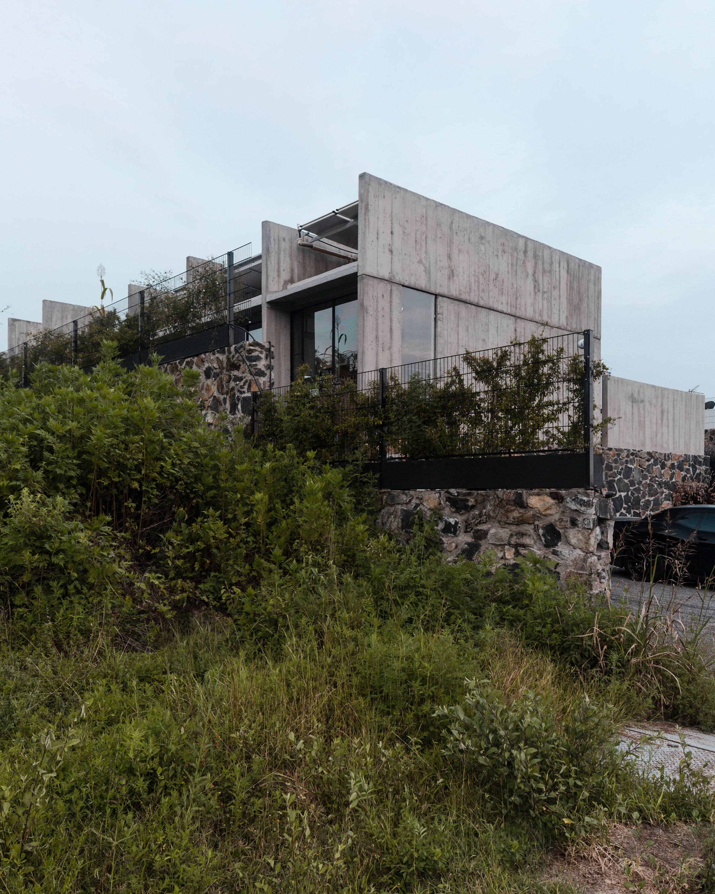 Board-marked concrete walls frame pool views from AT House