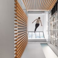 Robitaille Curtis stretches trapeze net across void at Atrium Townhome in Montreal
