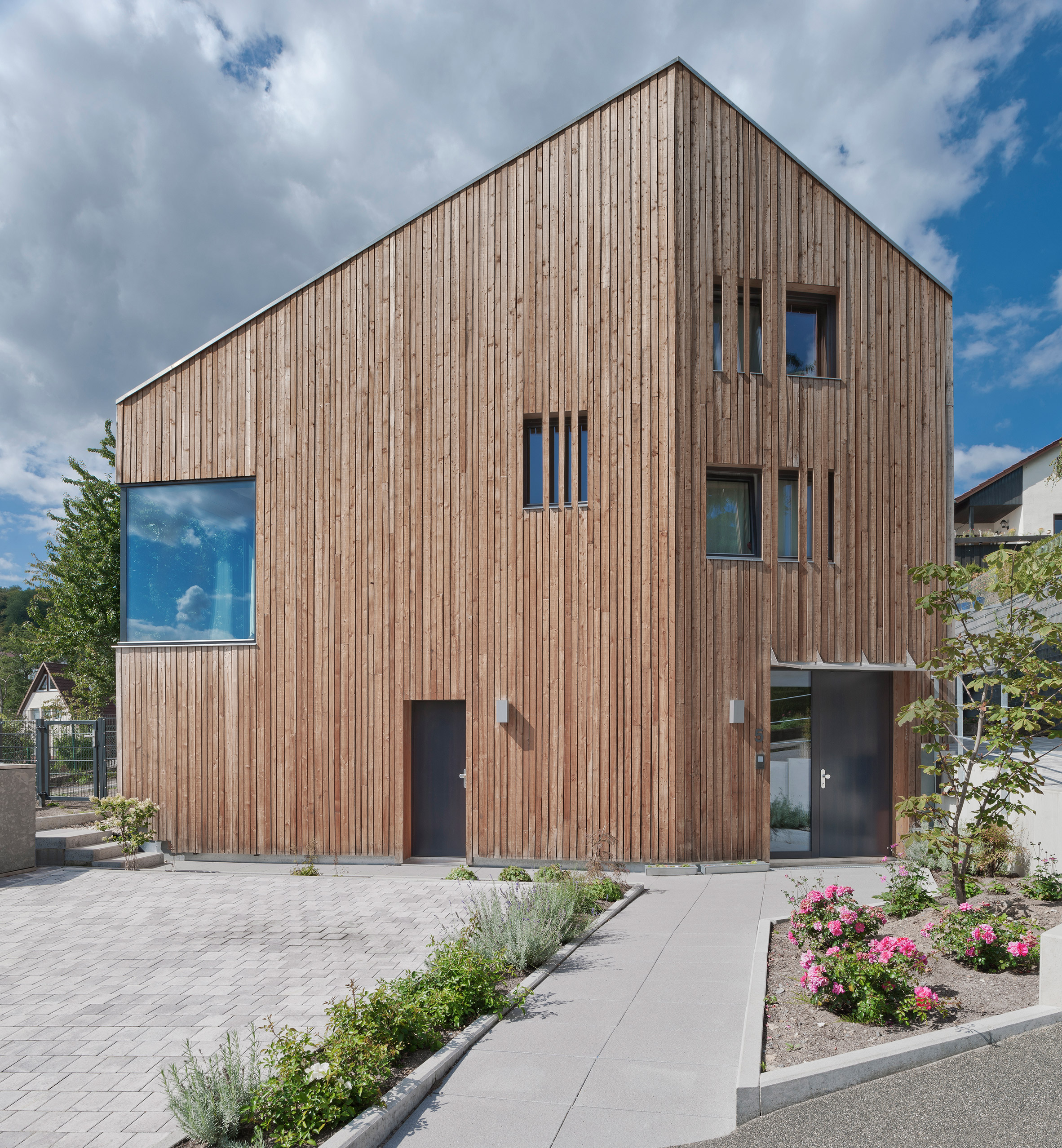 Arklab creates matching larch-clad houses with "the same DNA"