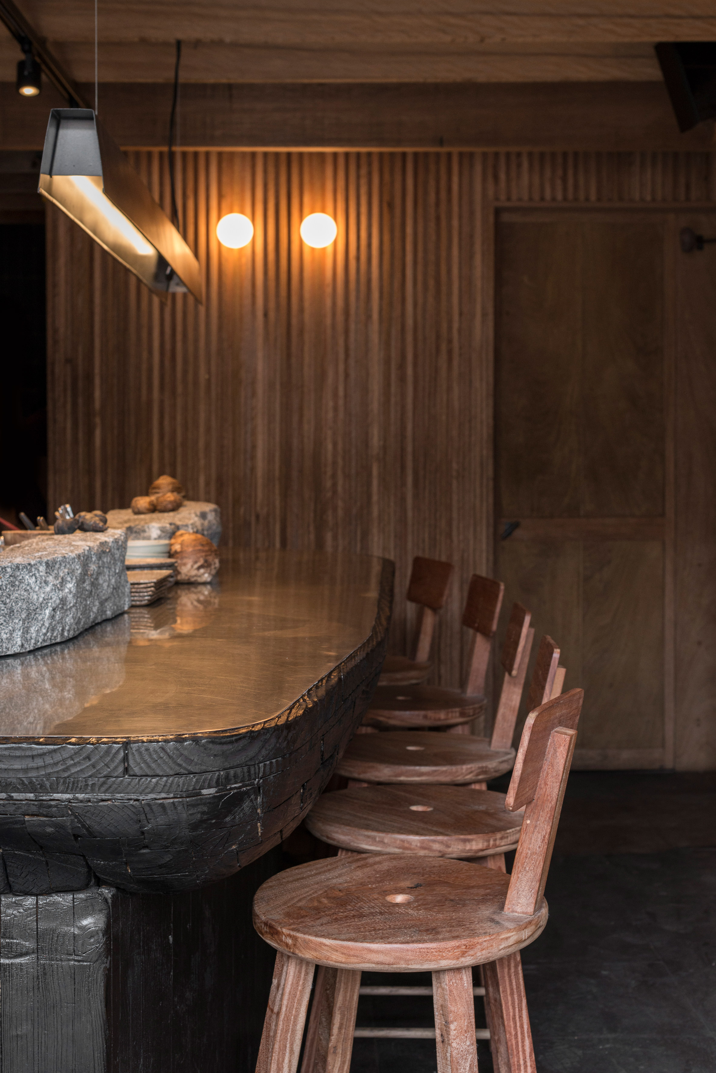 Wood, stone and adobe create cosy interior for Lima's Mérito restaurant by Ghezzi Novak