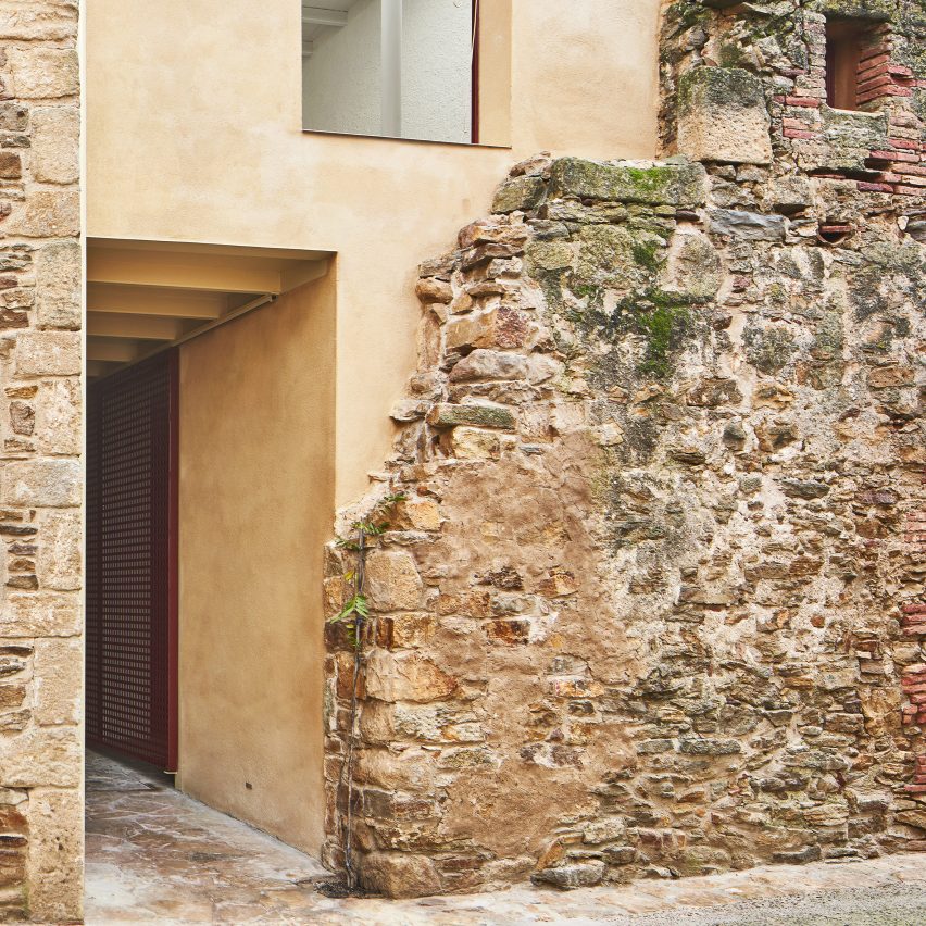 Arquitectura-G builds modern house behind crumbling old stone walls