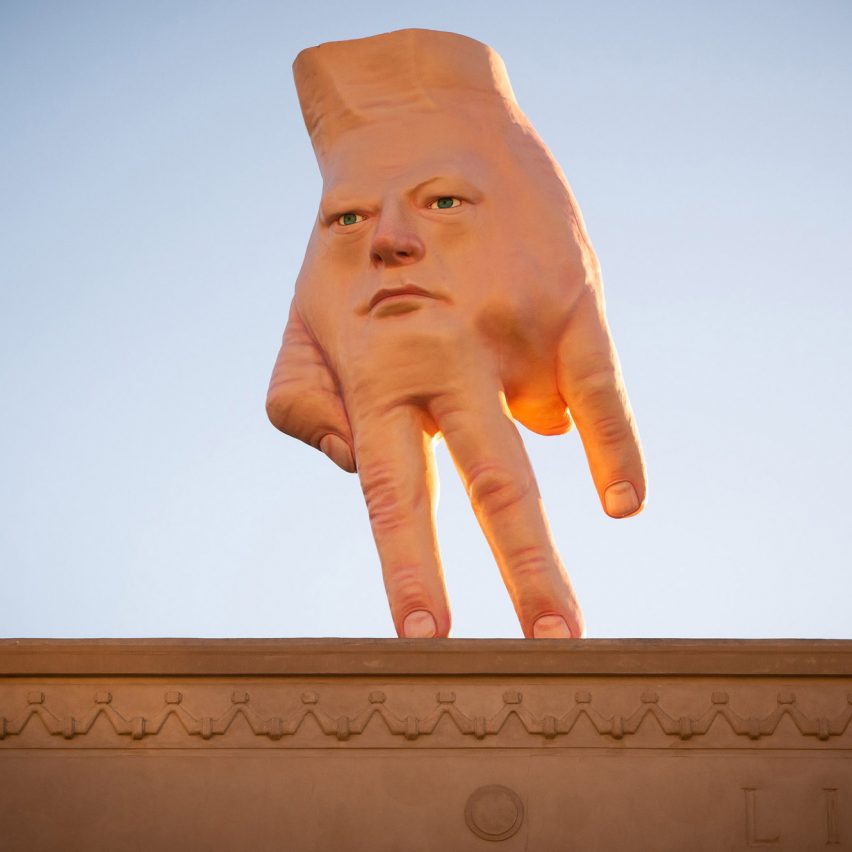 "Giant hybrid face-hand" installed on roof of art gallery in Wellington