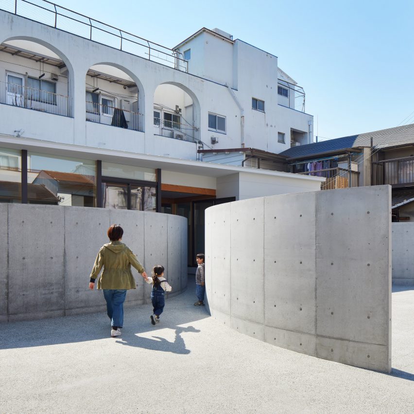 Arced concrete walls invite visitors into House in Konohana