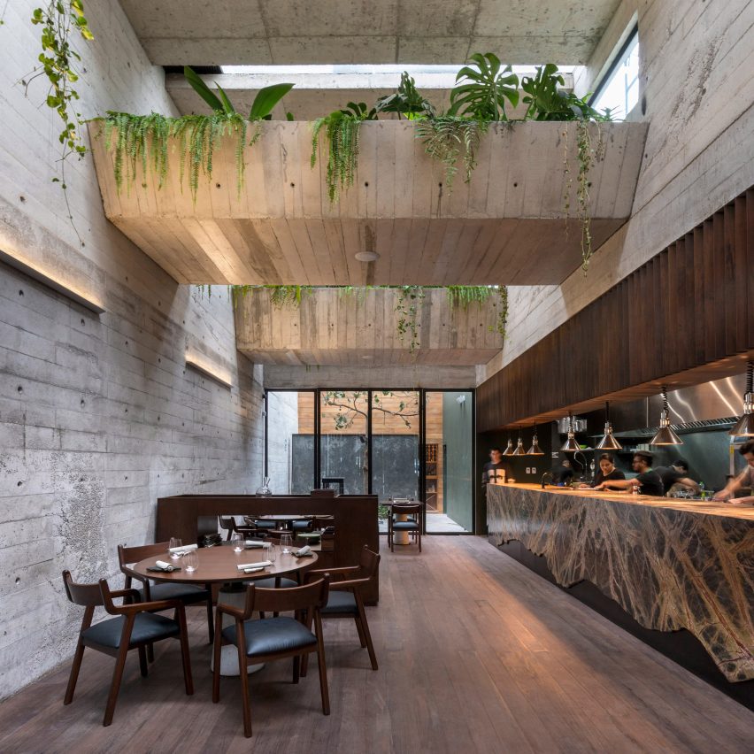 Greenery spills over chunky concrete beams in Lima's Statera Restaurant