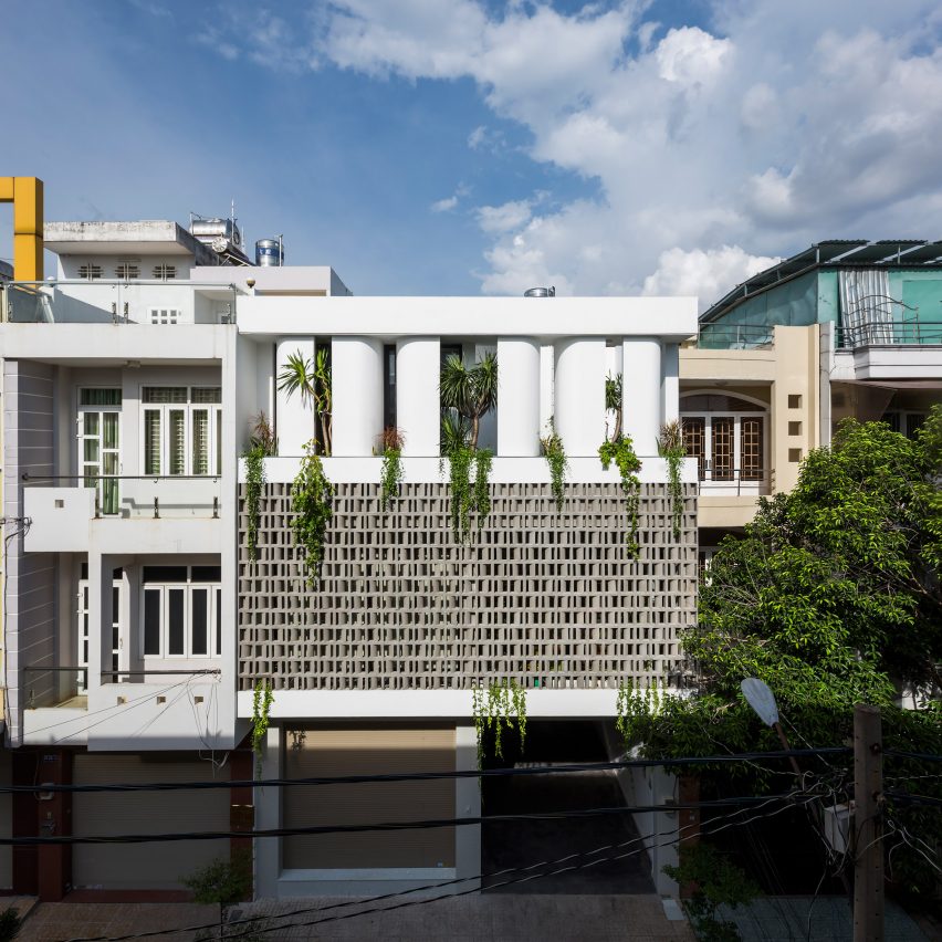 Perforated brick facade shades a house in Vietnam with a triple-height atrium