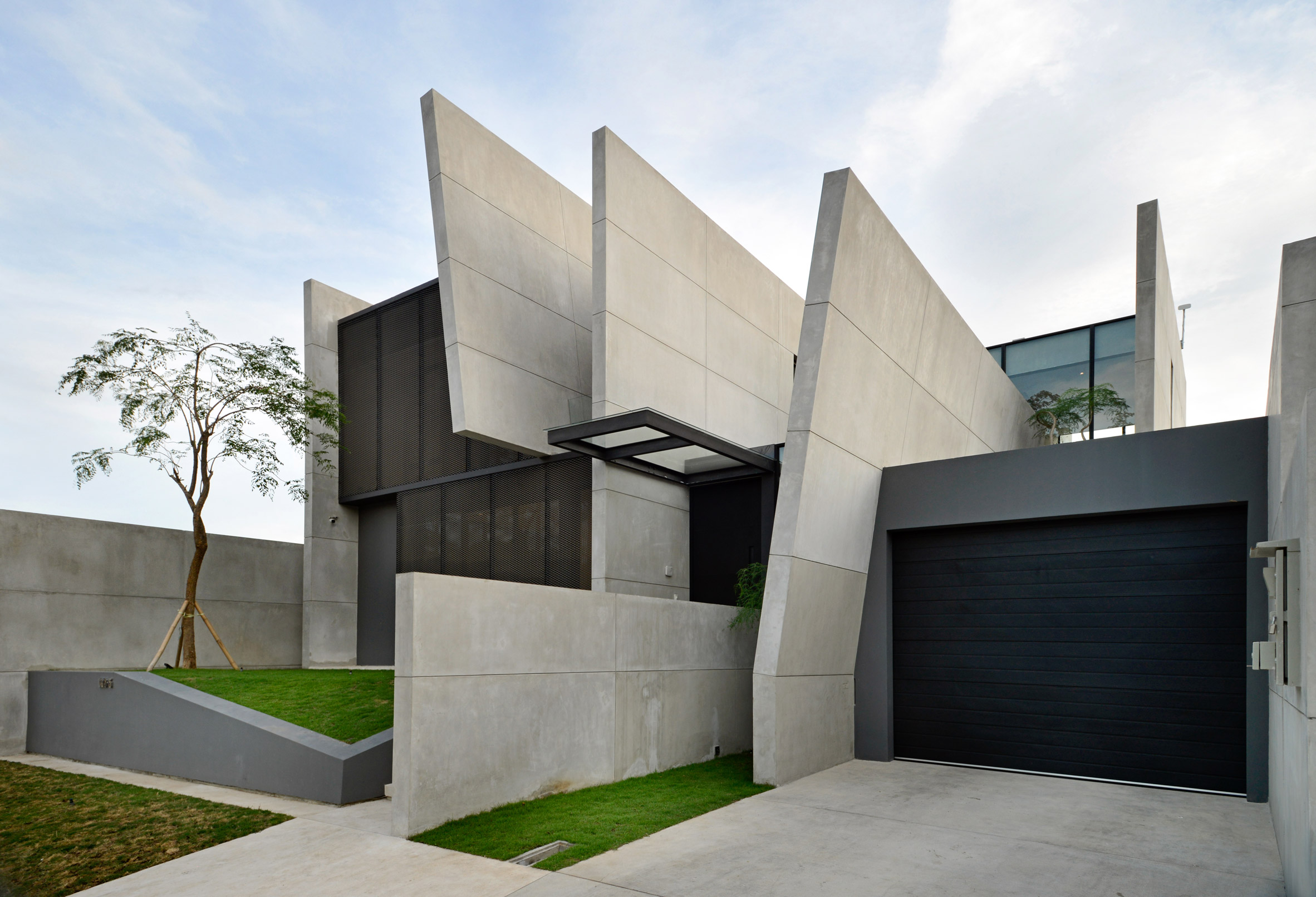 Parallel concrete walls divide up JJ House by Ivan Priatman Architecture
