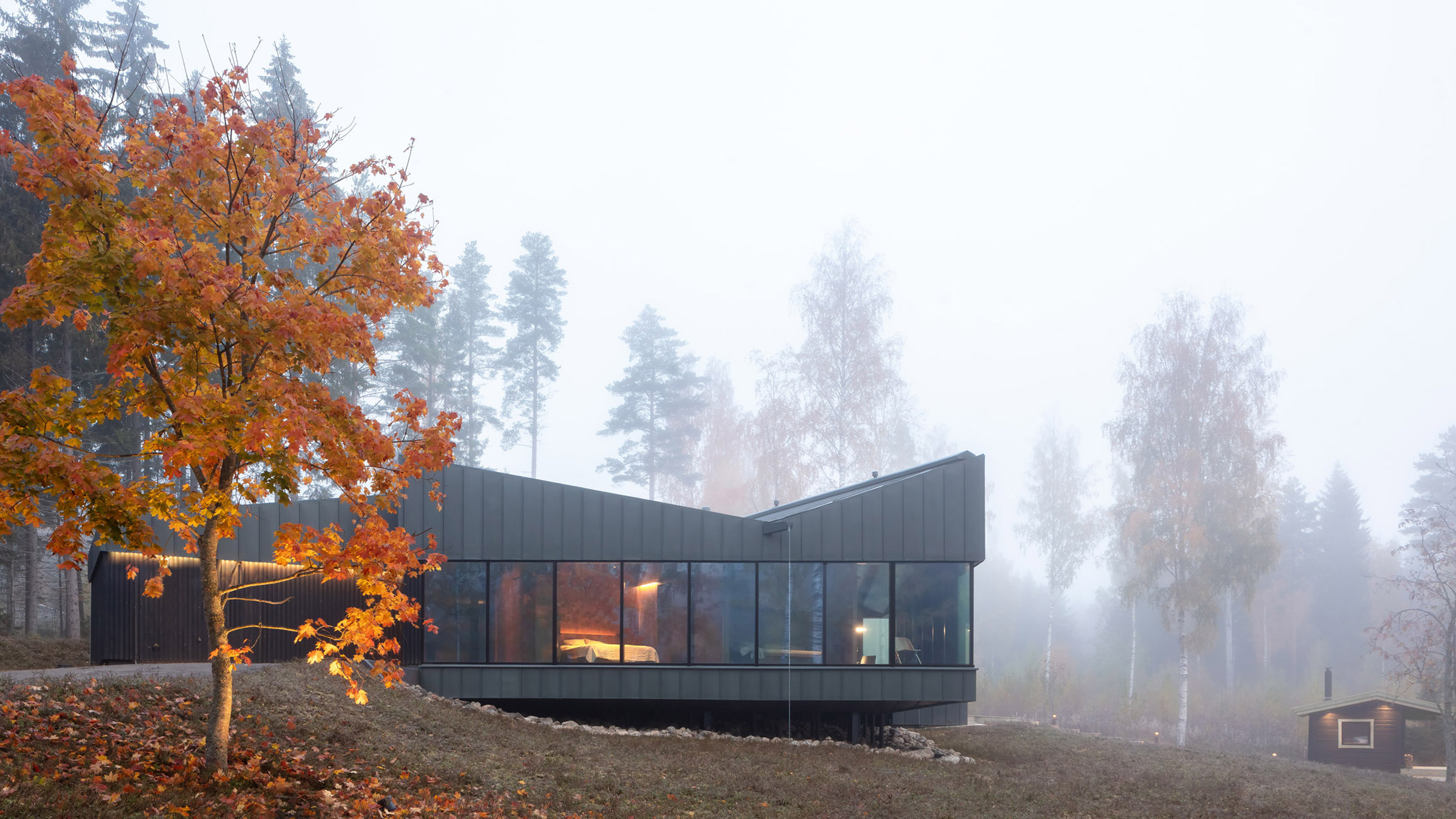 Studio Puisto designs black and zink house next to a Finnish lake