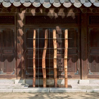 Dividir los muebles de Shinkyu Shon contrasta con troncos de madera de acero espejo