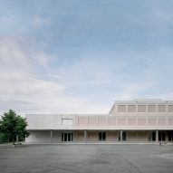 Pale pink shutters shade classrooms of a concrete school in Switzerland