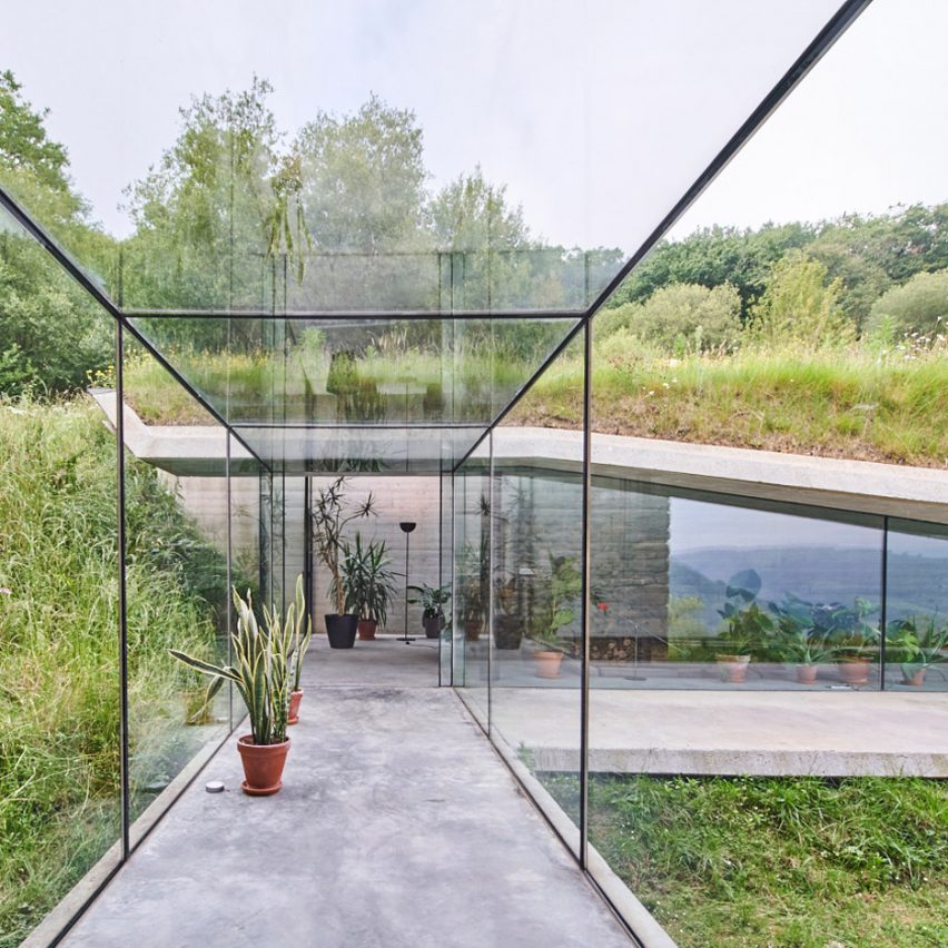 Glass corridor connects underground concrete extension to house in Spain