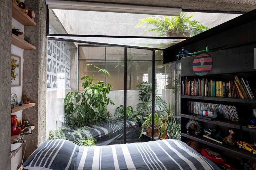 A bedroom overlooking a plant-filled courtyard