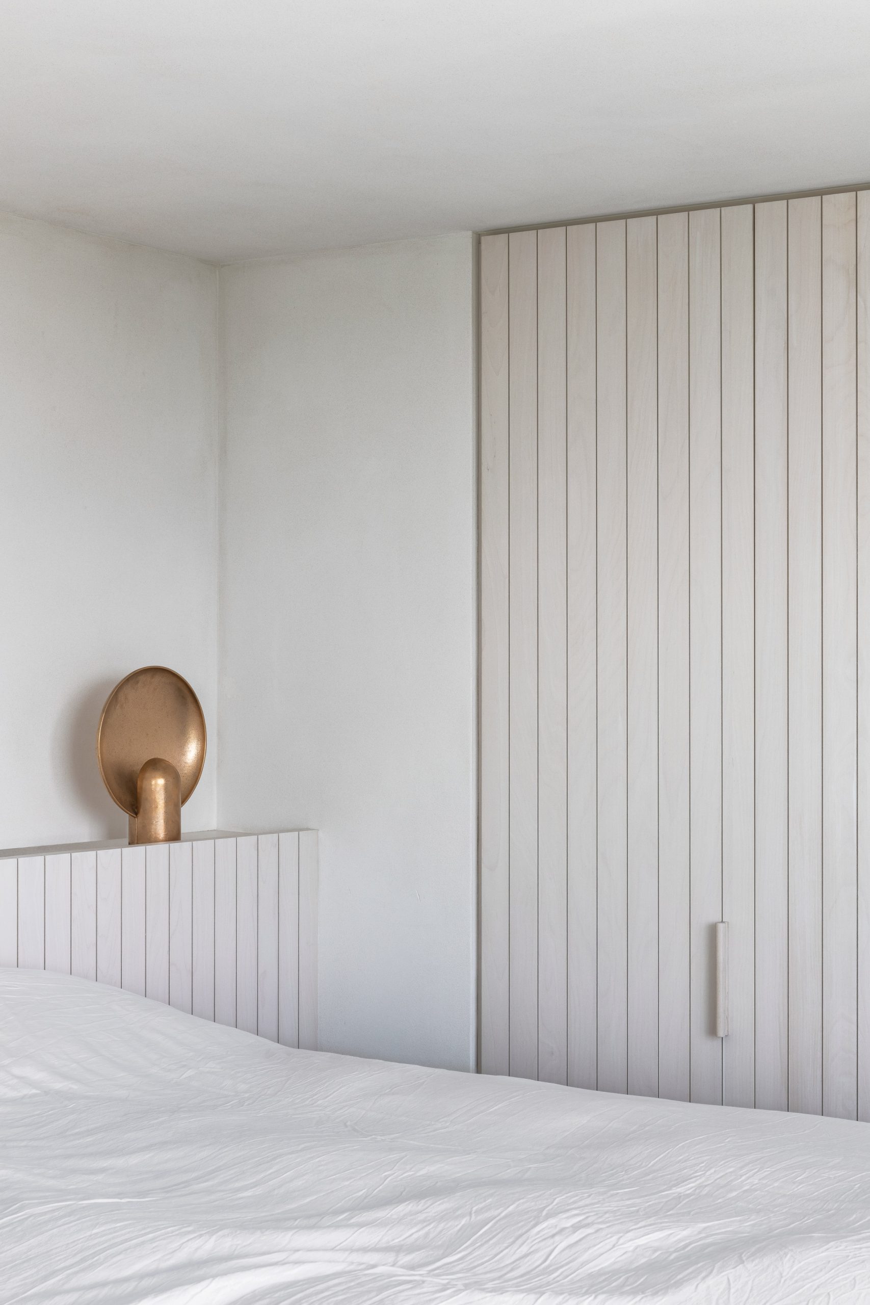 Bedroom of Belgian apartment features white joinery