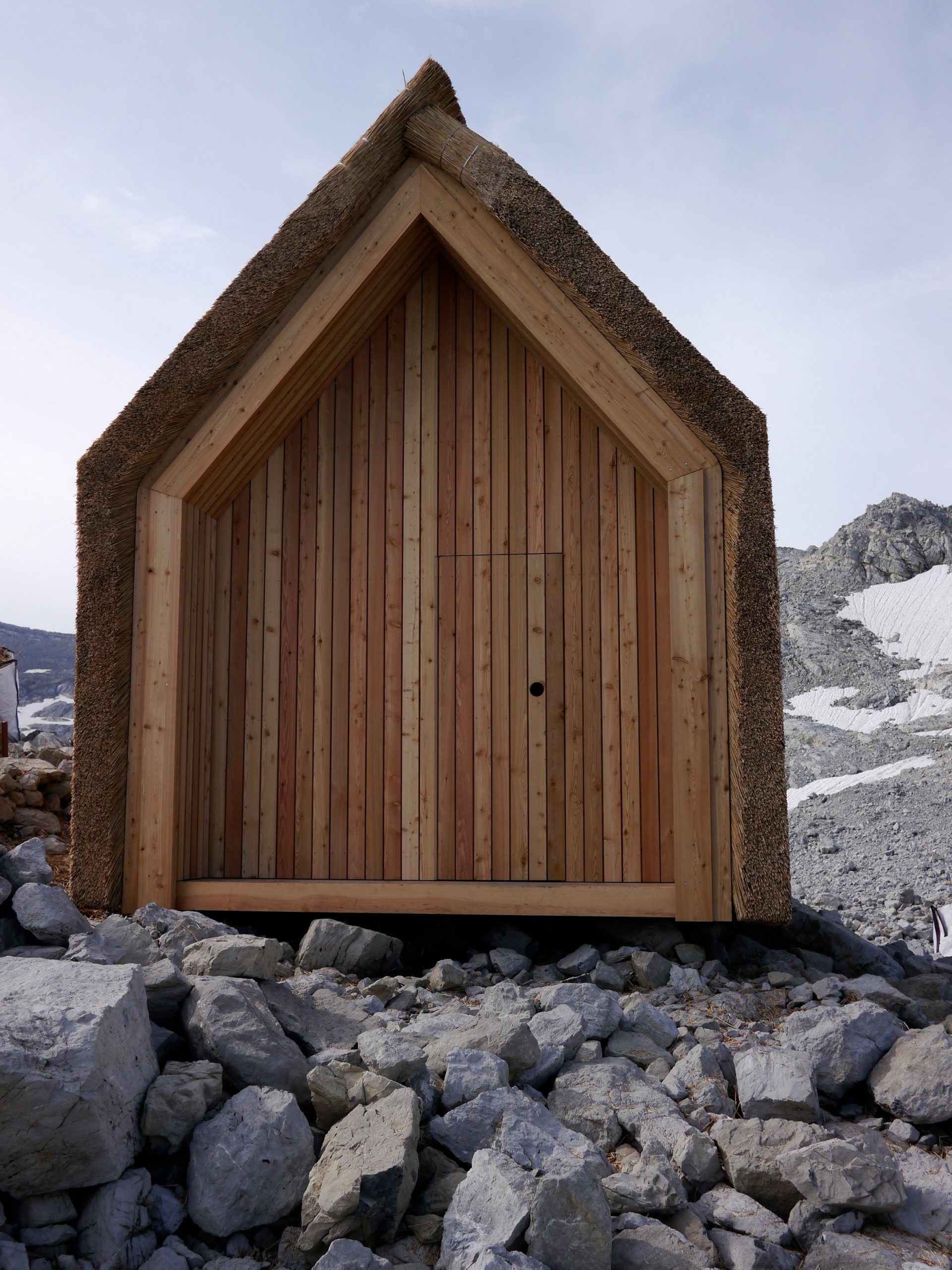 Exterior of thatched Alpine hut by University of Stuttgart