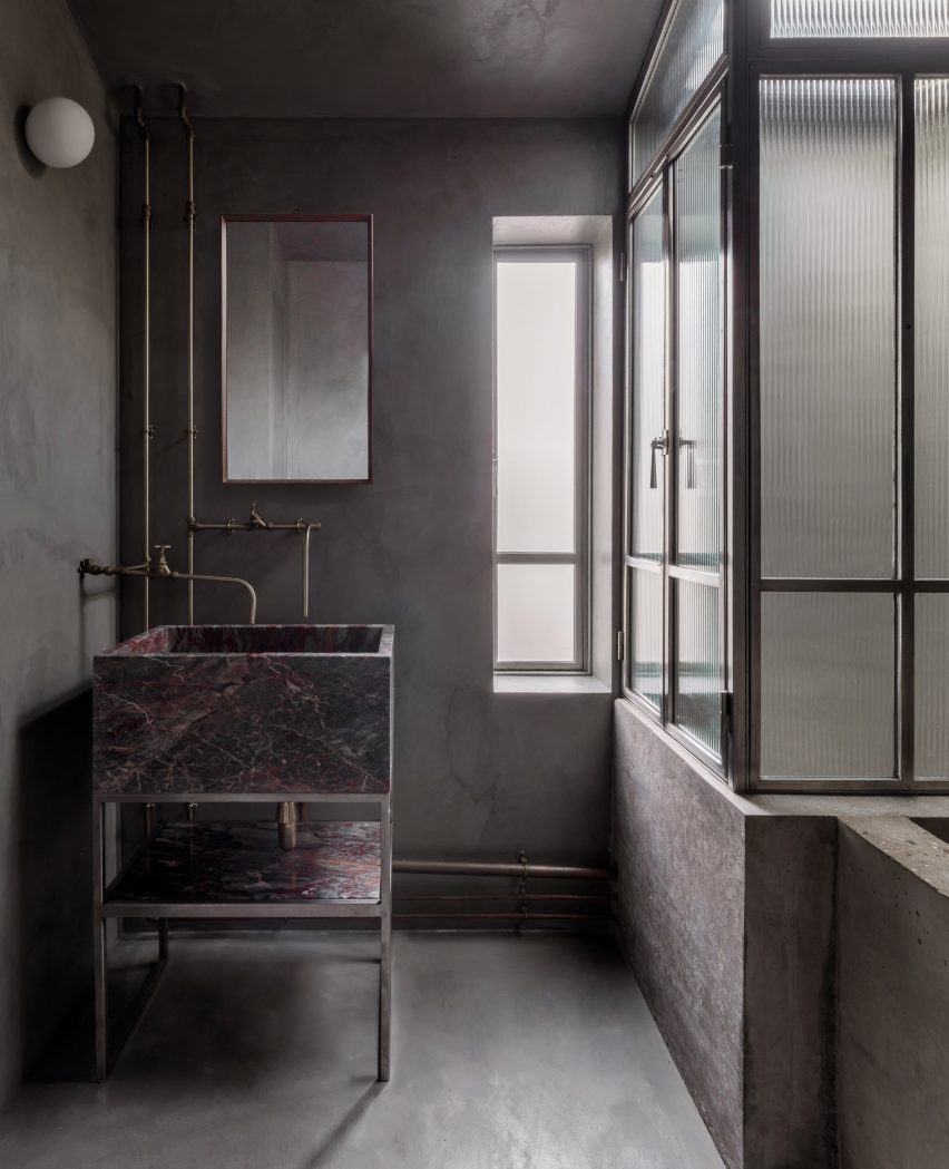 Concrete bathroom, stone washbasin and Crittal bathroom screen in Untiled house extension by Szczepaniak Astridge in London