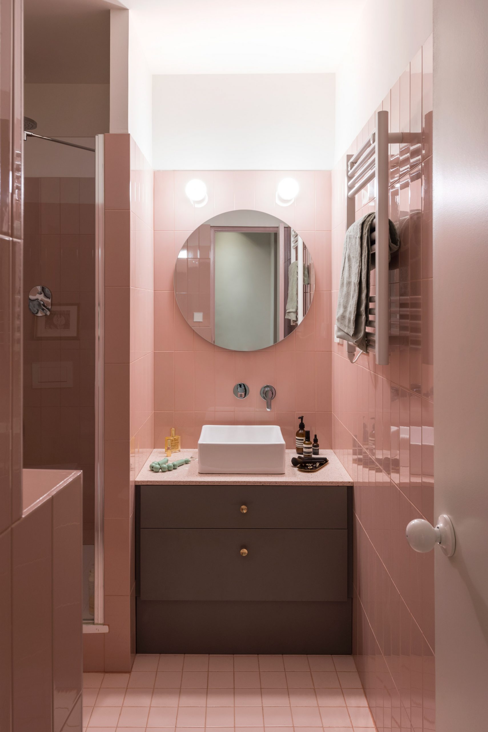 Pink-tiled bathroom with a grey vanity unit