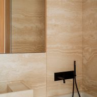 Travertine marble bathroom of Botaniczna Apartment by Agnieszka Owsiany Studio