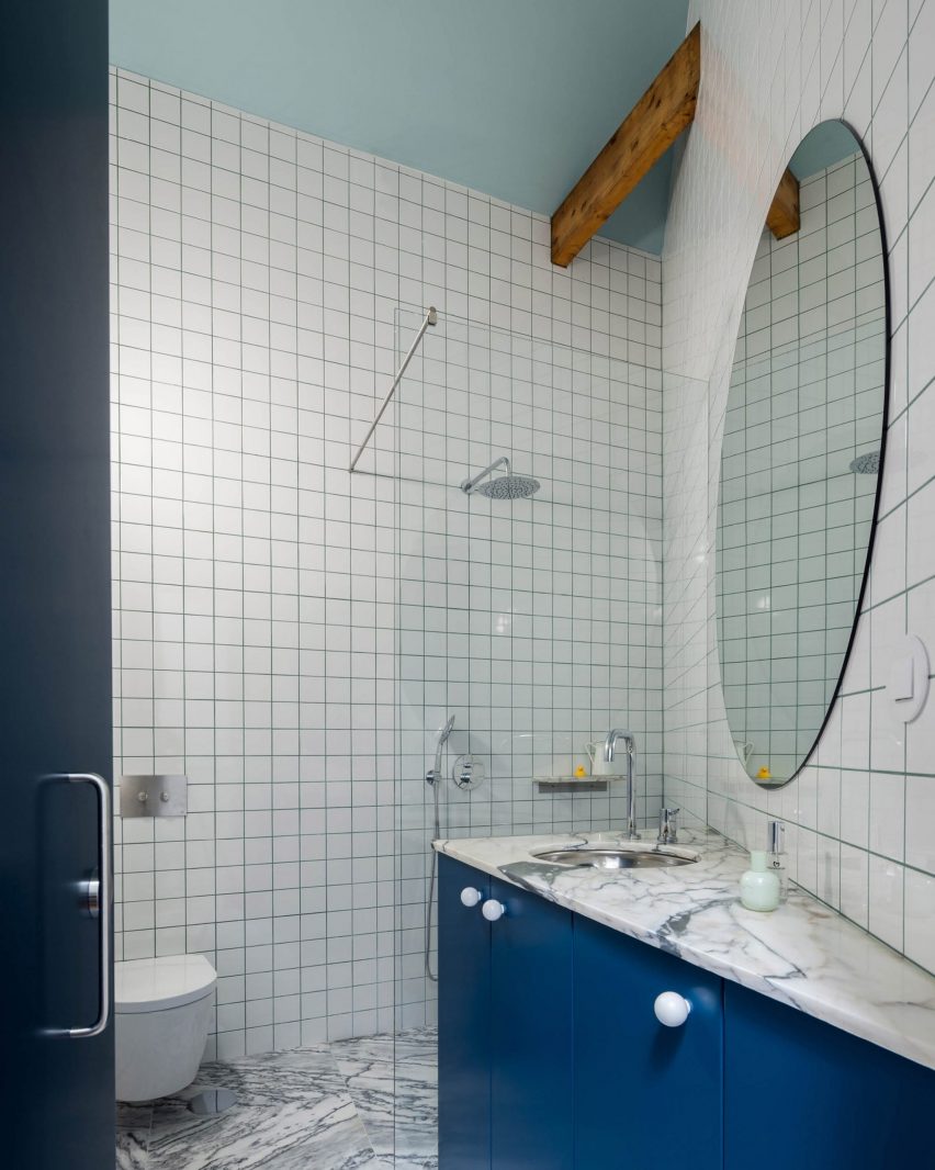Kamar mandi dengan ubin putih persegi