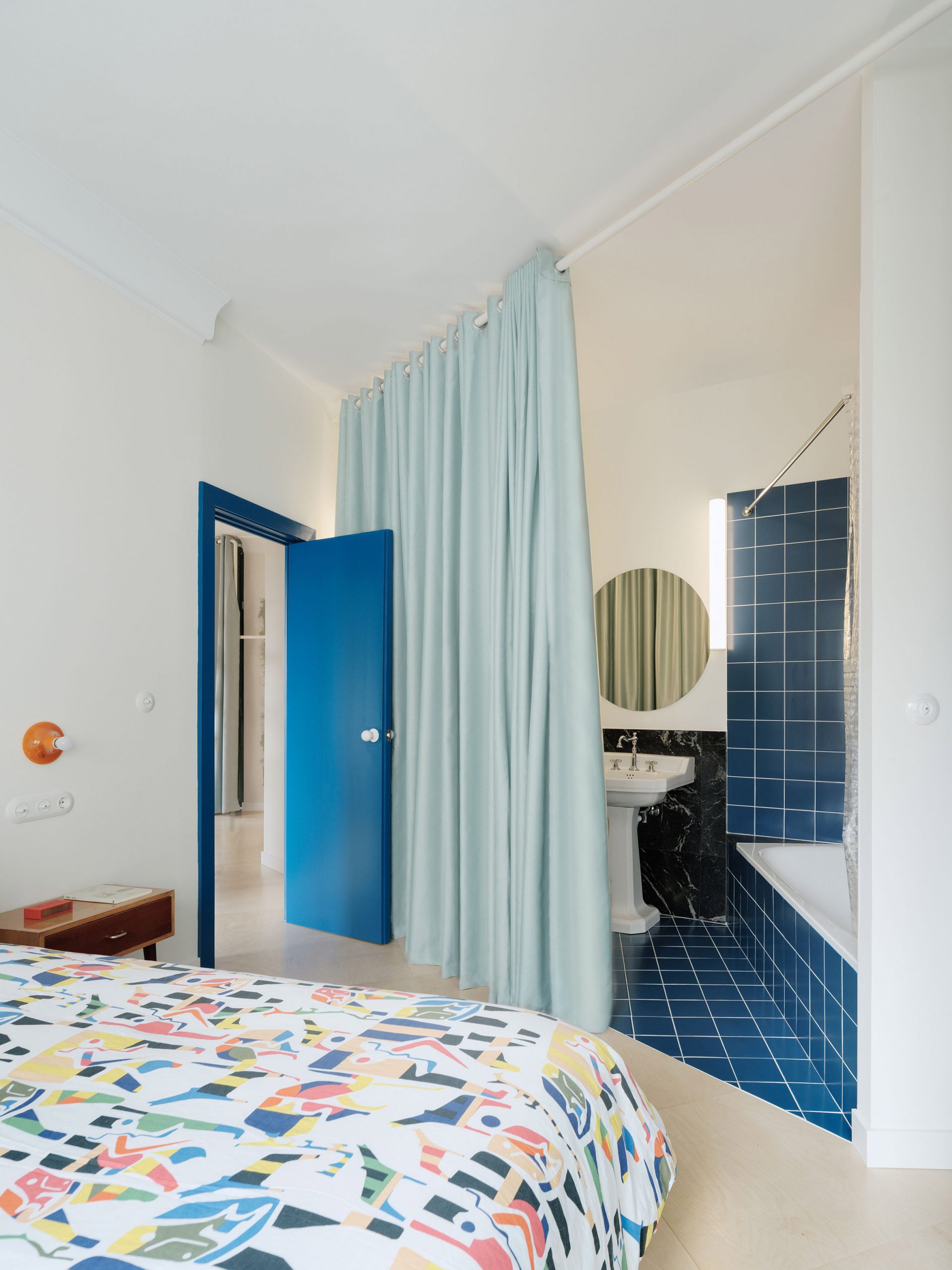 A bathroom with shower and bathtub clad in blue tile