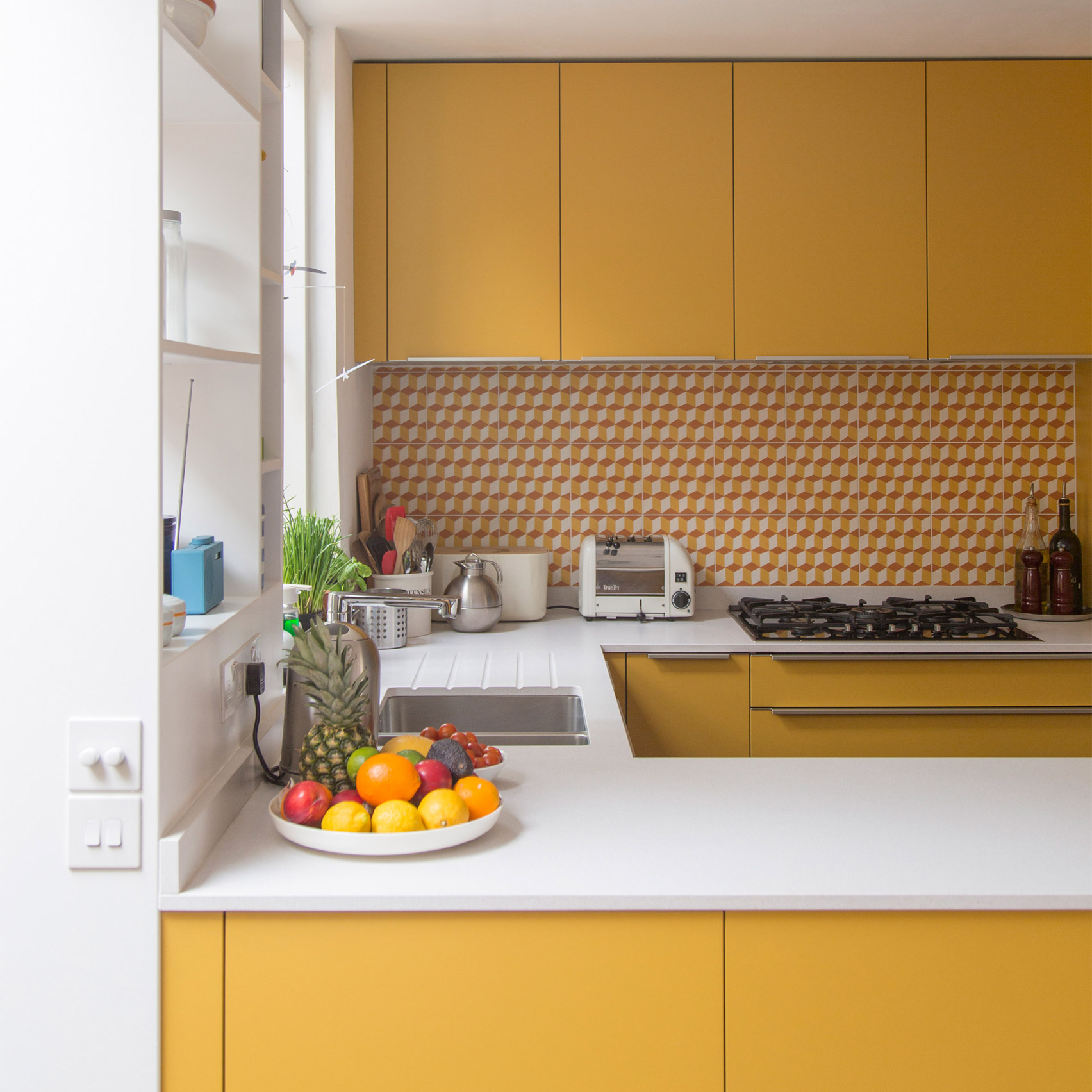Mustard yellow kitchen with orange splashback tiles