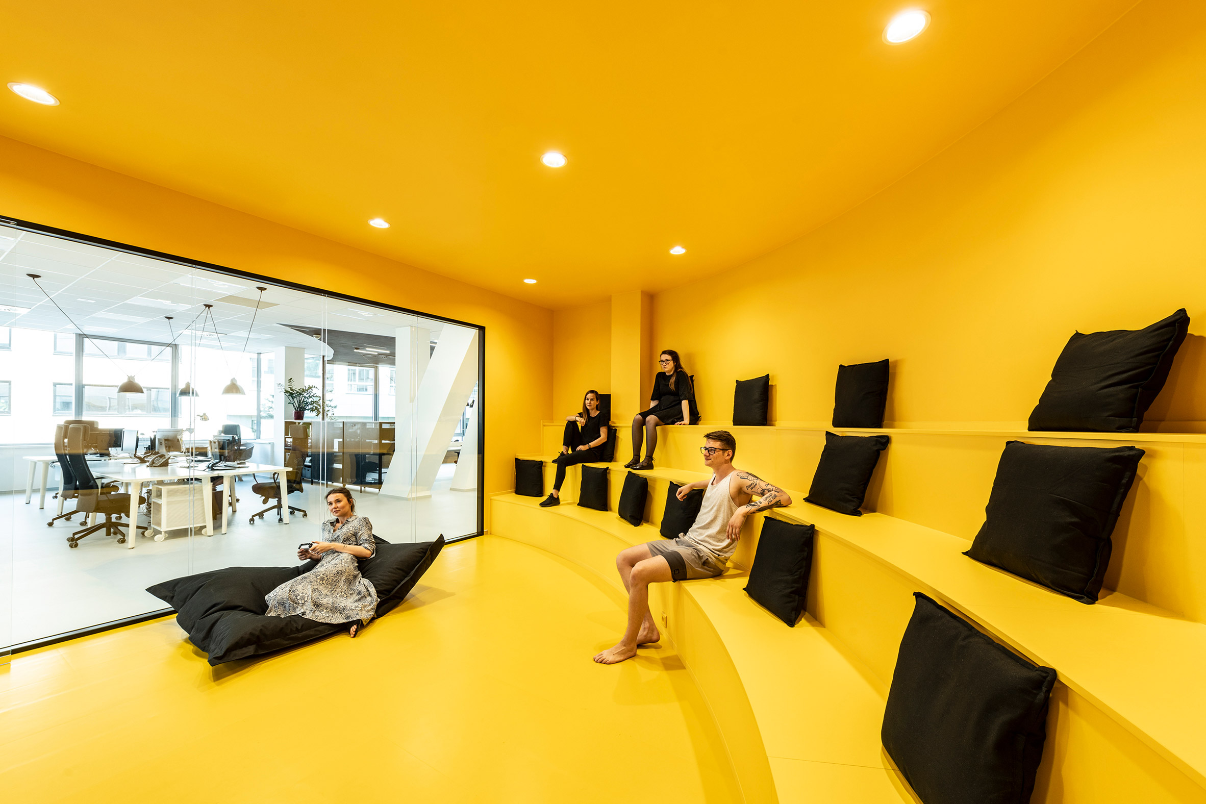Yellow amphitheatre seating inside the office for DDB Prague by B2 Architecture, Czech Republic