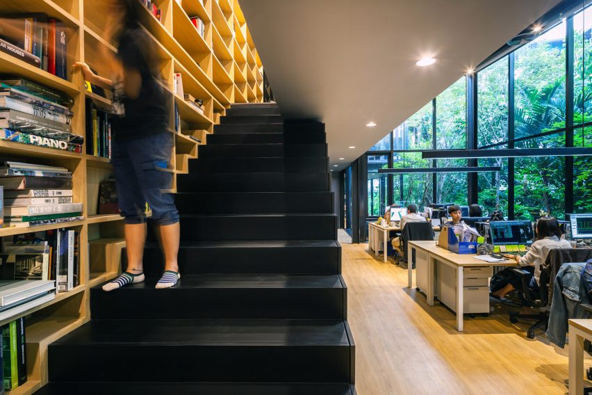 A bookshelf and staircase inside IDIN Architects Office in Bangkok, Thailand