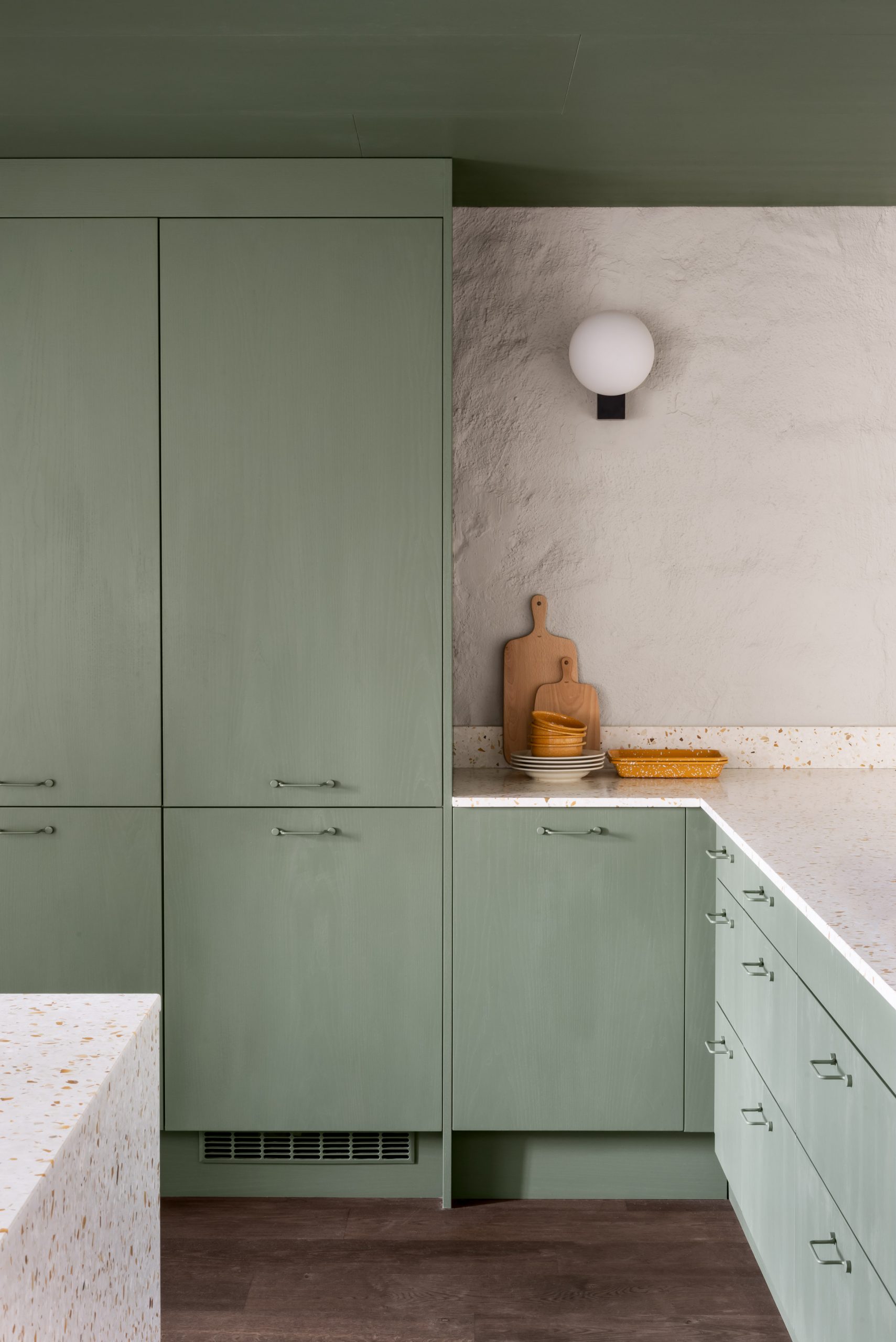 Pale green kitchen with terrazzo tops