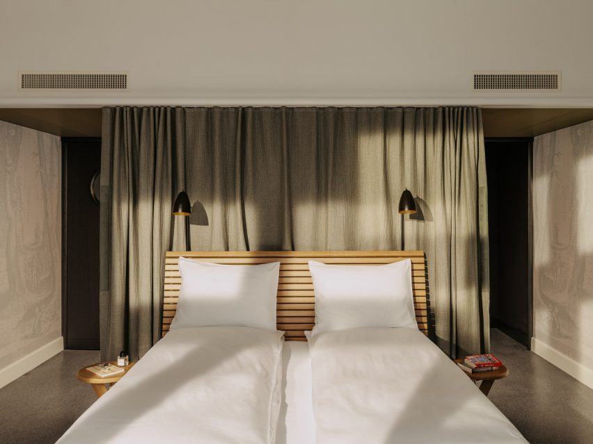 Bed with oak-slatted headboard in hotel bedroom