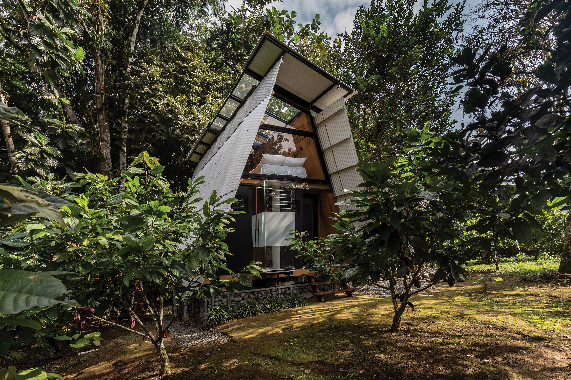 Prefabricated Huaira cabin nestles within verdant farmland in Ecuador