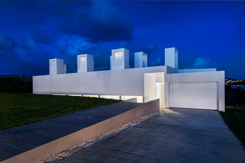 Nighttime exterior of concrete Casa Flores by Fuster + Architects