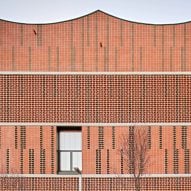 Assorted bricks give texture to facade of Camp del Ferro sports centre in Barcelona