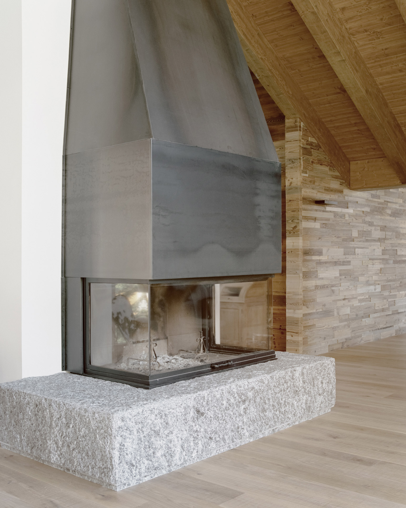 A fireplace inside an Italian chalet by LCA Architetti