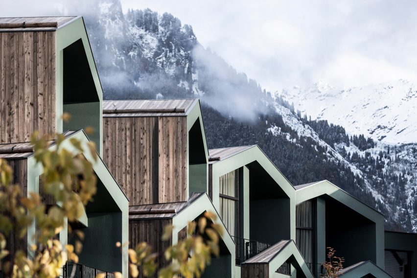 Wood clad and green painted structures against mountain