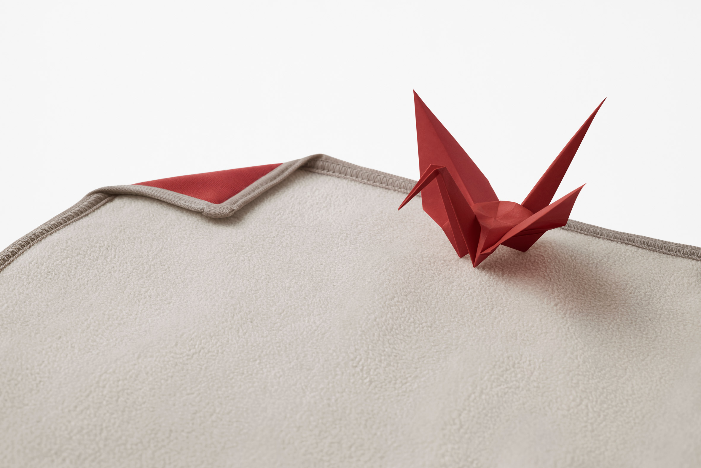 Red origami crane and blanket by Nendo for Japan Airlines