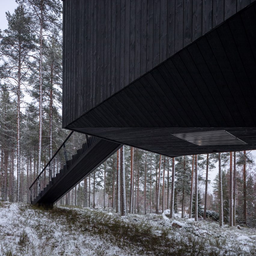 An elevated cabin with black-painted wood cladding 