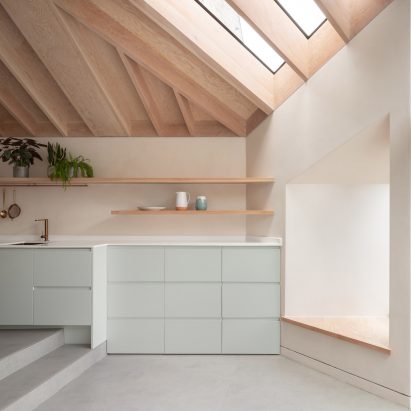 一个住宅厨房，带有暴露的木材天花板和鸭蛋蓝色橱柜