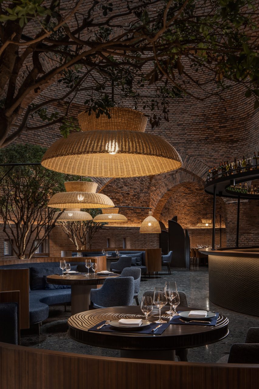A restaurant with red-brick walls and woven lampshades