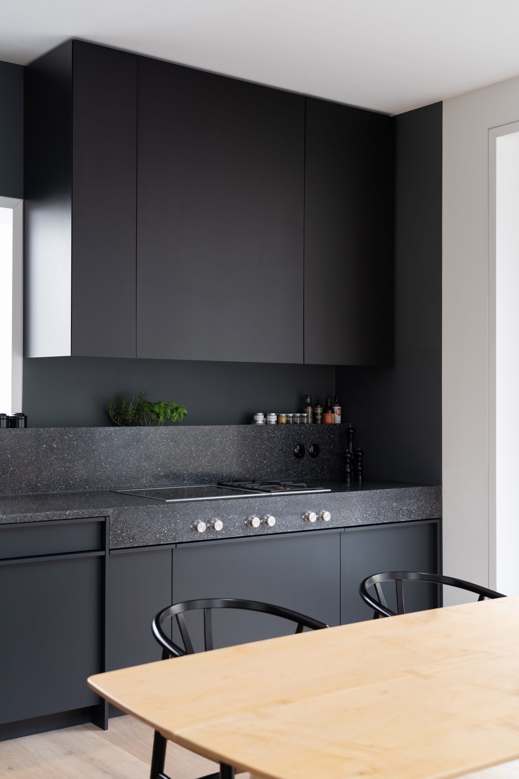 Dark grey kitchen contrasts against the light interior