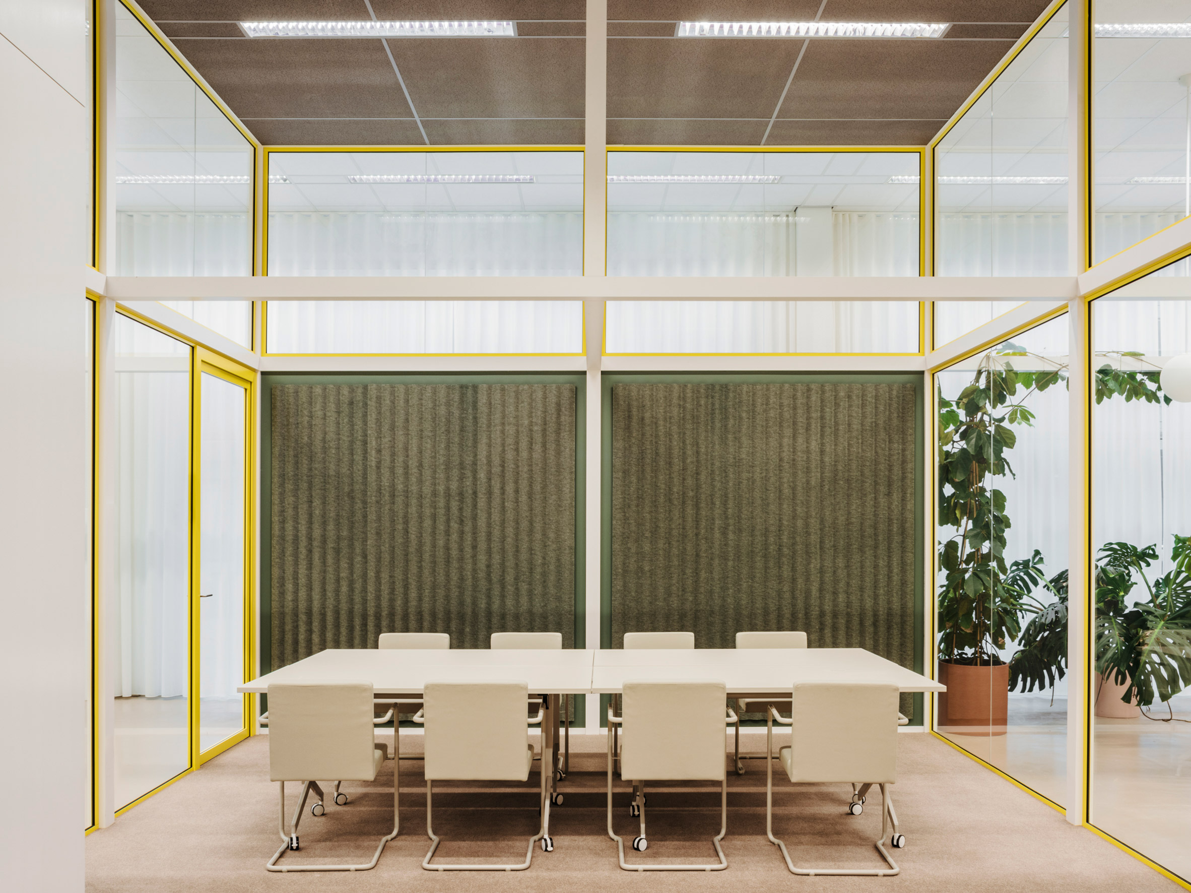 Meeting table in glass room with felt wall